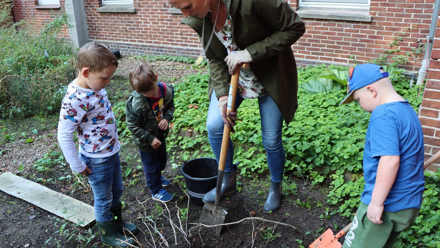 3 Kinder und eine Frau bei einer Gartenarbeit