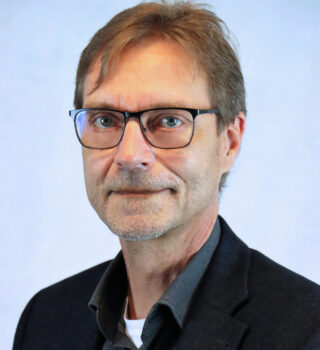 Jörg Namuth. Ein Mann mit einer Brille und dunklen kurzen Haaren