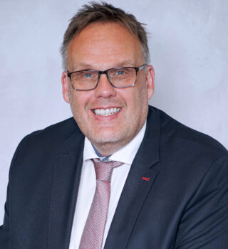 Klaus Puschmann. Ein Mann mit einer Brille und einen Anzug mit einer Krawatte