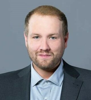 Nils Gastmann. Ein Mann mit dunklen Haaren und einen. Er trägt einen Anzug