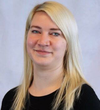 Christina Onken. Eine Frau mit langen blonden Haaren. Sie hat ein Piercing