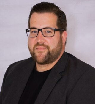 Thorsten Knickmeyer. Ein Mann mit kurzen dunklen Haaren. Er trägt eine Brille und einen Bart