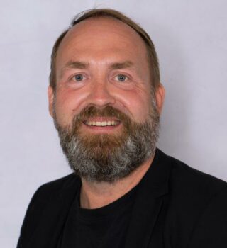 Oliver Kuhnt. Ein Mann mit kurze dunkle Haare und Bart