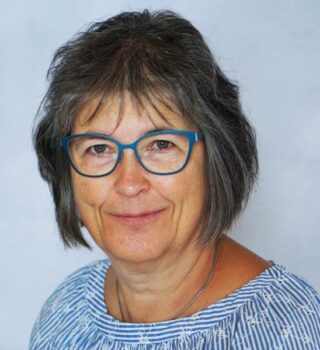 Inge Märkle. Eine Frau mit Brille und schulterlangen grauen Haaren