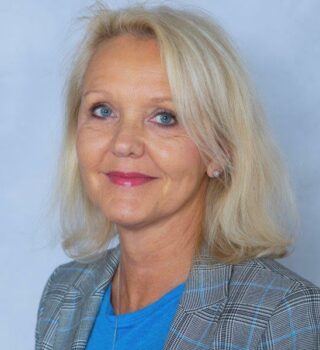 Britta Reusch-Sieberns. Eine Frau mit schulterlangen blonden Haaren. Sie trägt Ohrringe