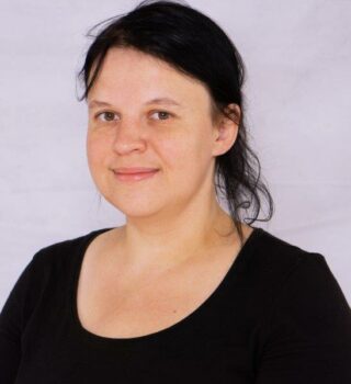 Katharina Röhrs. Eine Frau mit langen dunklen Haaren mit Zopf