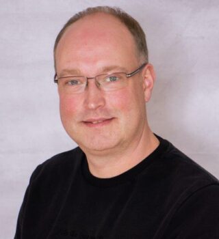 Frank Tempel. Ein Mann mit kurzen grauen Haaren und einer Brille
